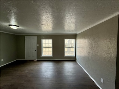 Empty room with a textured wall, ornamental moldin
