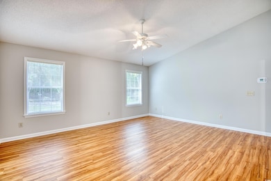 Empty room featuring a ceiling fan, baseboards, li