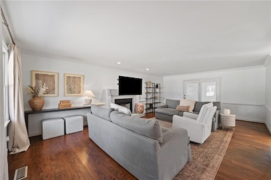 Living room with ornamental molding, visible vents