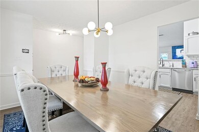 Dining room with wood finished floors and a chandelier