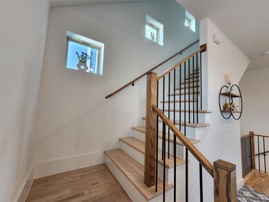 Wood stairs up to all levels. Window niches along 