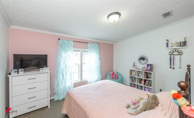 Bedroom featuring ornamental molding, carpet floor
