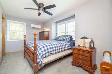 Carpeted bedroom with multiple windows, ceiling fa