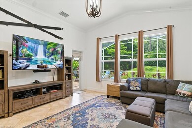 Living area featuring vaulted ceiling, healthy amount of natural light, light tile patterned floors, a chandelier, and crown molding