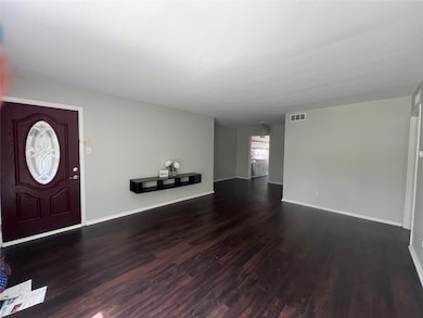 Entrance foyer featuring dark wood-style floors and baseboards