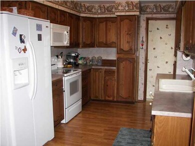 The updated kitchen has wood laminate floors. All 