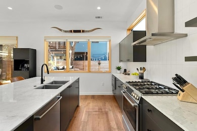 Kitchen with light stone counters, a sink, light 