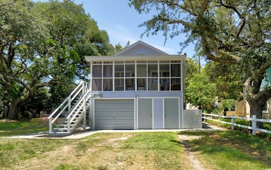 Back of property with a sunroom, a garage, driveway, and stairway