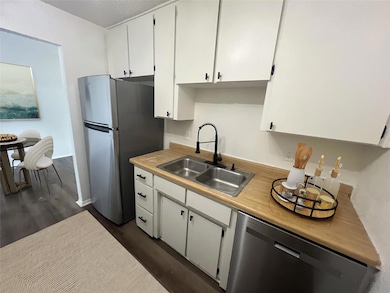 Kitchen featuring a sink, light countertops, dark 