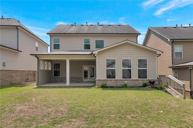 Rear view of property featuring brick siding, a pa