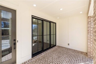 Enjoy a seamless indoor-outdoor lifestyle with this covered patio just off the terrace level media room featuring modern black-framed sliding glass doors. *Photos are of previously built Barnsley I floor plan. Actual homesite is under construction and wi