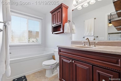 Bathroom with vanity, a bath, and light tile patterned floors