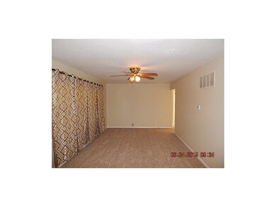 Living room with drapes, ceiling fan.