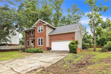 View of front of property featuring brick siding, driveway, and a shingled roof