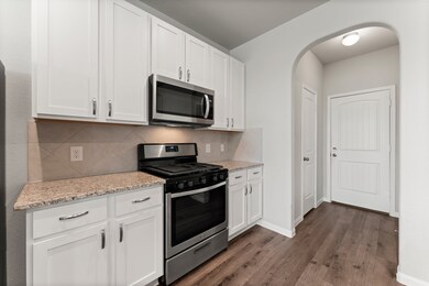 Kitchen features white cabinets, Whirlpool applian