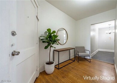 Entryway with wood finished floors and a chandelier