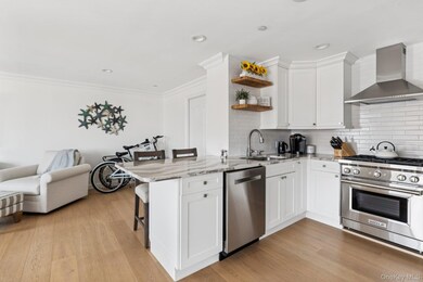 Kitchen with wall chimney range hood, stainless steel appliances, open shelves, a peninsula, and backsplash