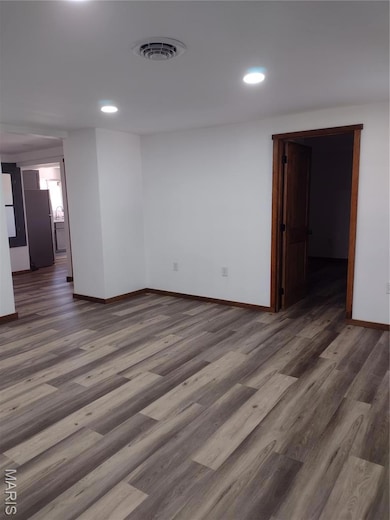 Empty room featuring wood finished floors and recessed lighting
