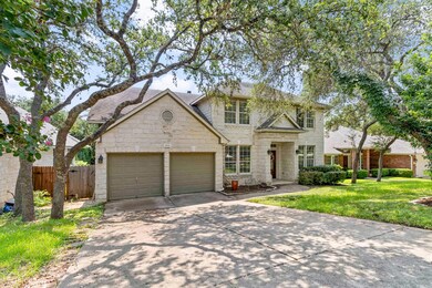 Traditional-style home with concrete driveway, a garage, roof with shingles, and stone siding