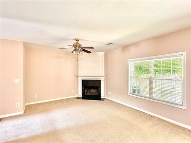 Unfurnished living room with carpet, ceiling fan, and a fireplace with flush hearth