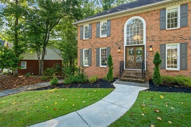 View of front of property with french doors, entry steps, a front lawn, and brick siding