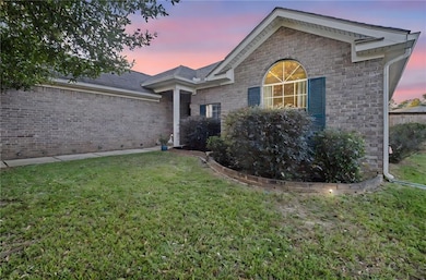 Single story home featuring a yard and brick siding