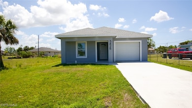 View of front facade featuring a front yard, concrete driveway, stucco siding, fence, and a garage