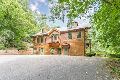 View of front of home featuring a balcony and fenc