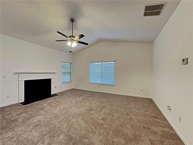 Unfurnished living room with a ceiling fan, lofted ceiling, and carpet flooring