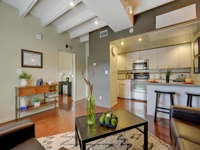 Living room with baseboards, beam ceiling, and vi