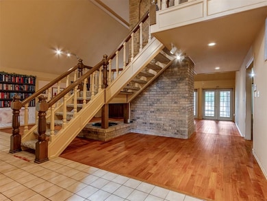 Stairway featuring brick wall, wood finished floors, and french doors