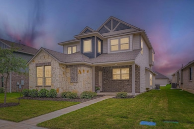 View of front of house with a yard, stone siding,