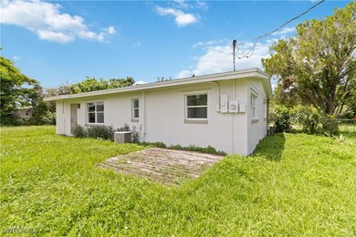 Rear view of property featuring a yard and central