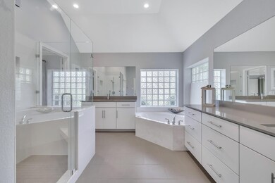 Full bath with a garden tub, two vanities, a stal