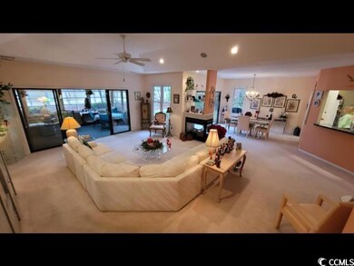 Carpeted living room featuring a multi sided firep