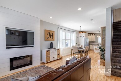 Living room featuring stairs, light wood-style floors, a chandelier, recessed lighting, and a fireplace