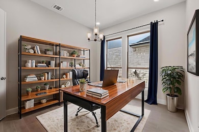 Office space featuring a chandelier, wood finishe