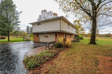 View of home's exterior featuring a lawn, driveway, a garage, and brick siding