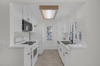 Kitchen with white appliances, light countertops,