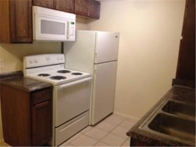 Kitchen featuring dark countertops, a sink, light