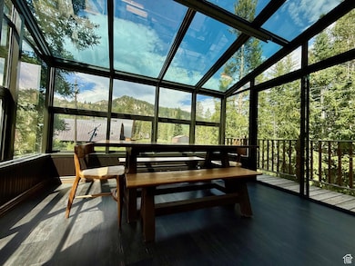 Sunroom with outdoor dining area and a mountain view