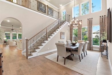 This spacious home features an elegant dining area with high ceilings and large windows, providing ample natural light. 