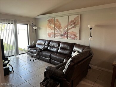 Living area with lofted ceiling, light tile patter