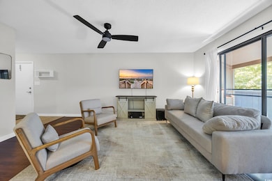 Living room with ceiling fan and a textured ceiling