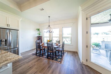 Dining space with ceiling fan with notable chandelier, crown molding, and dark hardwood / wood-style flooring