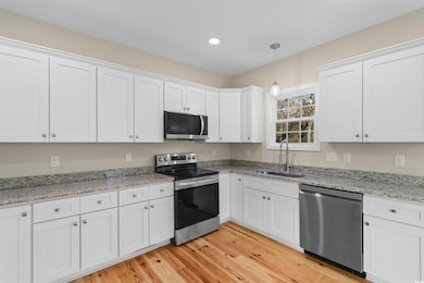 Kitchen with a sink, light wood-style floors, whit
