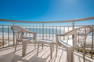 Balcony featuring view of water and beach