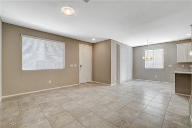 Unfurnished living room with a chandelier, light t
