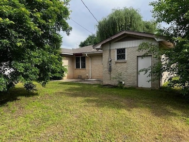 Back of property with brick siding and a lawn
