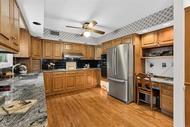 Tons of cabinet and counter space in the expanded kitchen. Kitchen boasts wood cabinets, granite counter tops, electric cook top with hood, microwave, oven, dishwasher, stainless French door refrigerator, & planning desk.
